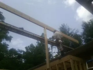Carpenter setting a ridge beam over a new addition frame — Ice Dam Removal by Roofing Brothers in North Dighton