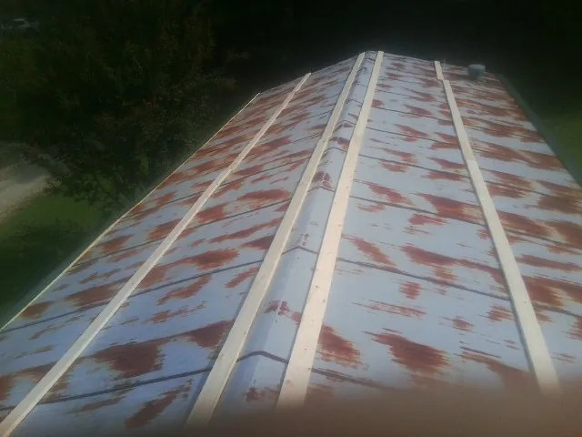Rusted metal roof panels with new wood purlins before replacement — Storm Damage Roof Repair in North Dighton by Roofing Brothers