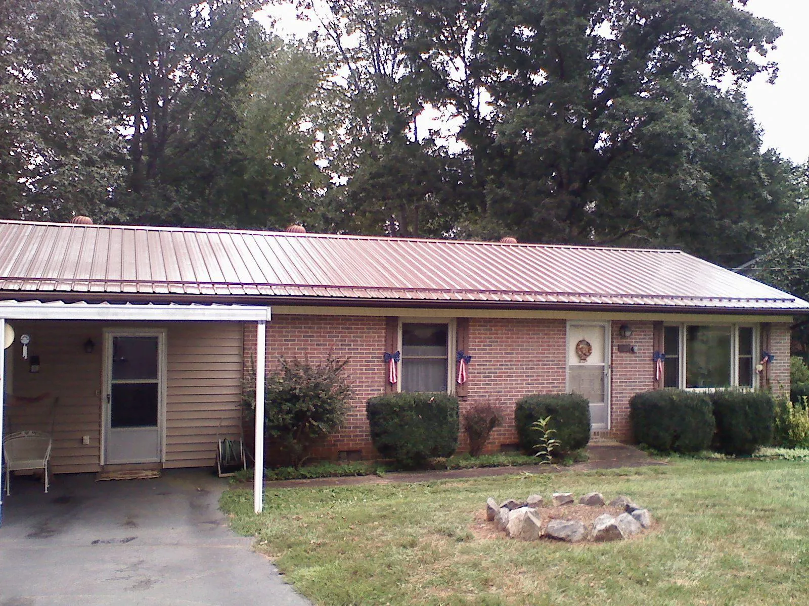 Bronze metal roof and carport on a brick ranch home — Roof Repair work by our crew in North Dighton